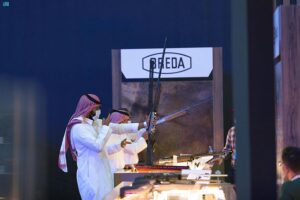 سيدة تجرب استخدام مسدساً في معرض الصقور والصيد في الرياض.